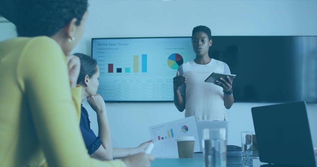 Businesswoman presenting sales tracker on tablet during meeting with charts and dashboard