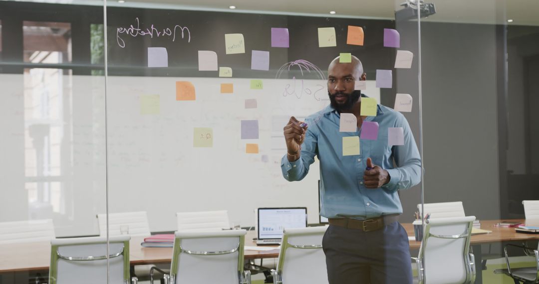 Businessman Brainstorming with Sticky Notes on Office Glass Wall - Free Images, Stock Photos and Pictures on Pikwizard.com