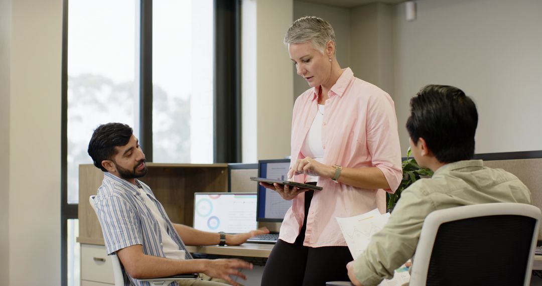 Diverse Team Collaborating in Modern Office Environment with Technology