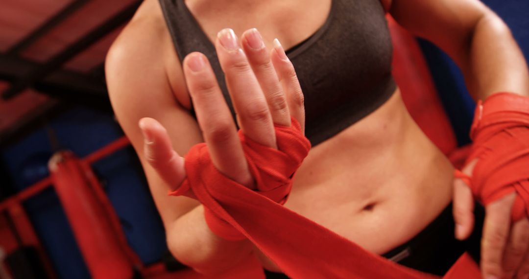 Female Boxer Wrapping Hands with Red Bandages Before Training Session - Free Images, Stock Photos and Pictures on Pikwizard.com