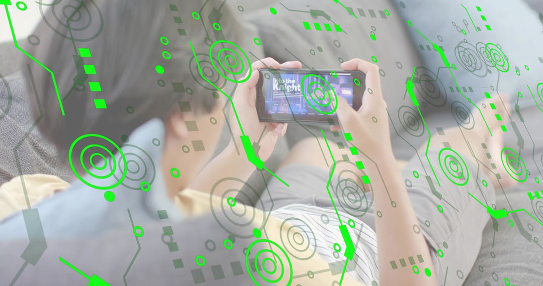 Asian man reclining on sofa playing mobile game with green AR HUD overlay