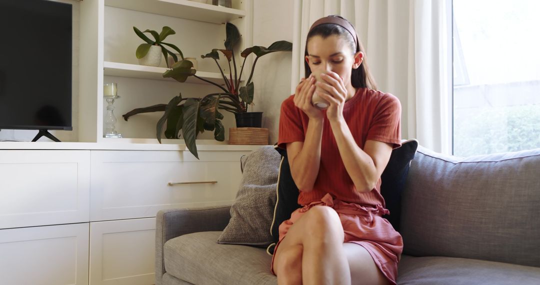 Woman Sipping Hot Beverage in Cozy Living Room