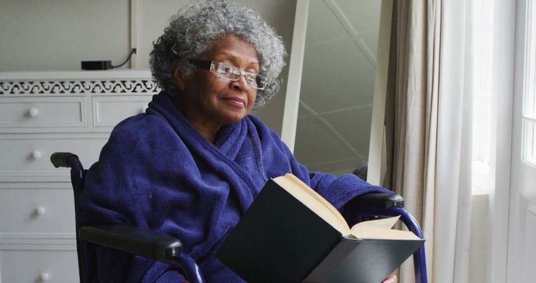 Senior Woman in Wheelchair Reading Book by Window - Free Images, Stock Photos and Pictures on Pikwizard.com