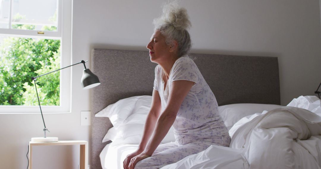 Elderly Woman Stretching on Bed in Bright Morning Light - Free Images, Stock Photos and Pictures on Pikwizard.com