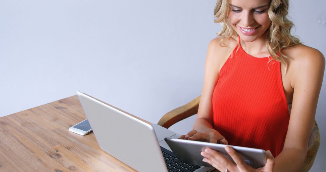 Smiling Woman Using Tablet and Laptop at Desk - Free Images, Stock Photos and Pictures on Pikwizard.com