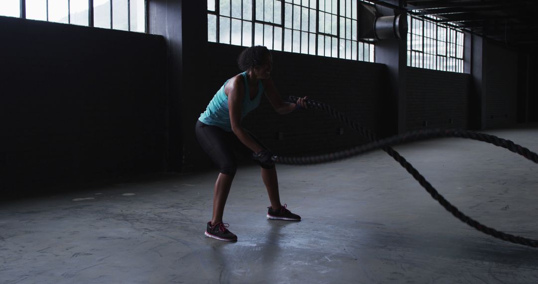 Woman Engaging in Battle Rope Workout in Industrial Gym - Free Images, Stock Photos and Pictures on Pikwizard.com