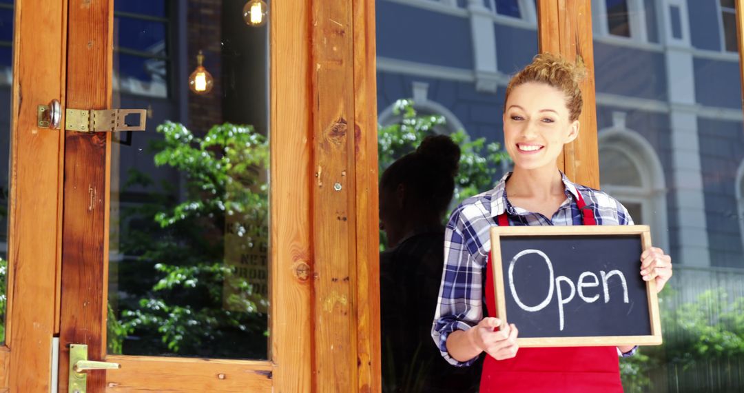 Smiling Woman Holding Open Sign at Small Business Entrance - Free Images, Stock Photos and Pictures on Pikwizard.com