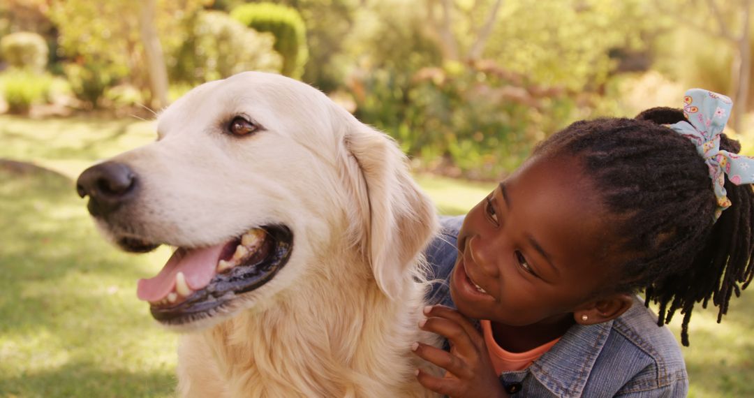 Joyful Child Embracing Golden Retriever in Sunny Park