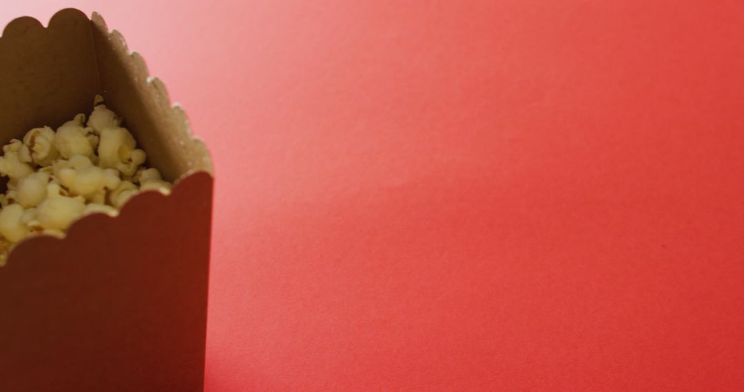 Close-up of Box of Popcorn on Vibrant Red Background - Free Images, Stock Photos and Pictures on Pikwizard.com