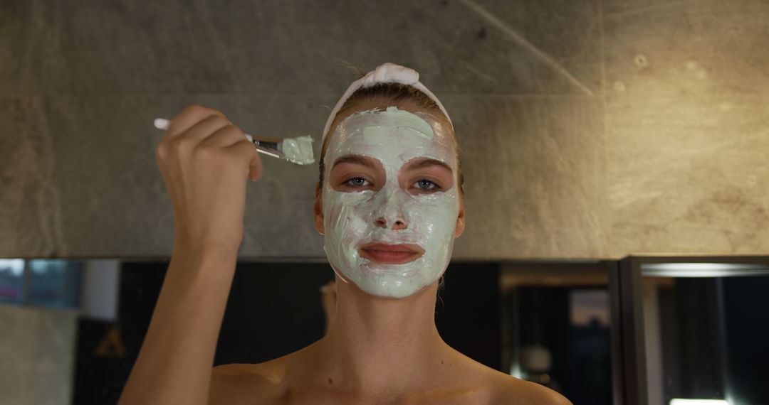 Woman Applying Facial Mask for Skincare Routine in Bathroom - Free Images, Stock Photos and Pictures on Pikwizard.com