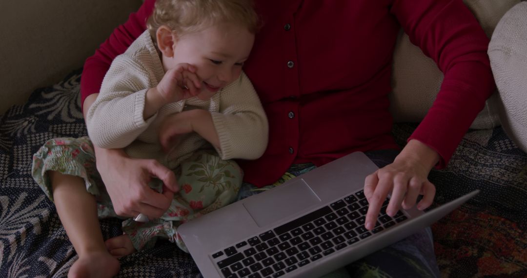 Mother Working on Laptop with Curled Toddler Beside Her - Free Images, Stock Photos and Pictures on Pikwizard.com