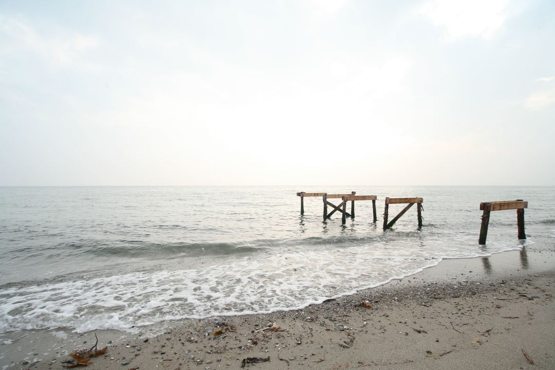 Tranquil Beach Scene With Dilapidated Pier - Free Images, Stock Photos and Pictures on Pikwizard.com