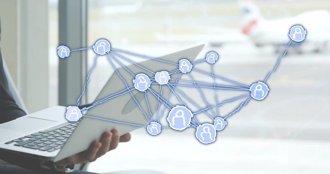 Executive holding laptop at airport accessing digital network for business connectivity