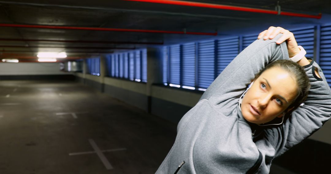 Woman Stretching Arms in Underground Parking Garage - Free Images, Stock Photos and Pictures on Pikwizard.com