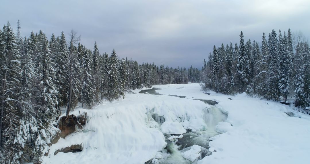 Aerial View of Snow Covered River and Frozen Waterfall in Winter Forest - Free Images, Stock Photos and Pictures on Pikwizard.com