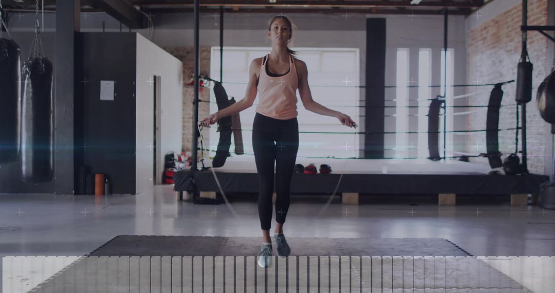 Athletic Woman Jumping Rope in Modern Boxing Gym Setting