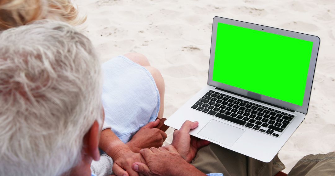 Senior Couple Using Laptop on Sandy Beach with Green Screen - Free Images, Stock Photos and Pictures on Pikwizard.com