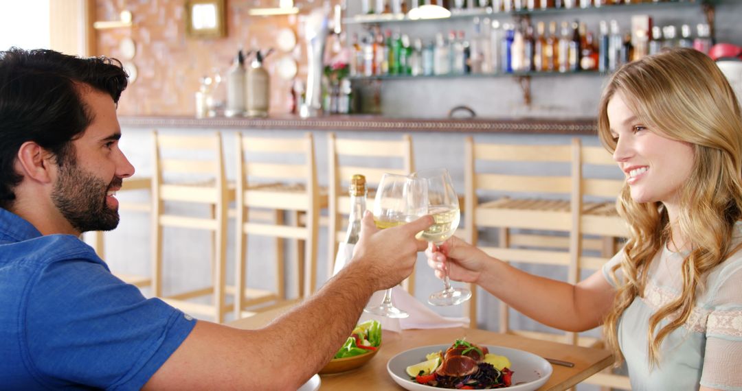 Couple Enjoying Romantic Dinner Date with Wine Toast at Restaurant