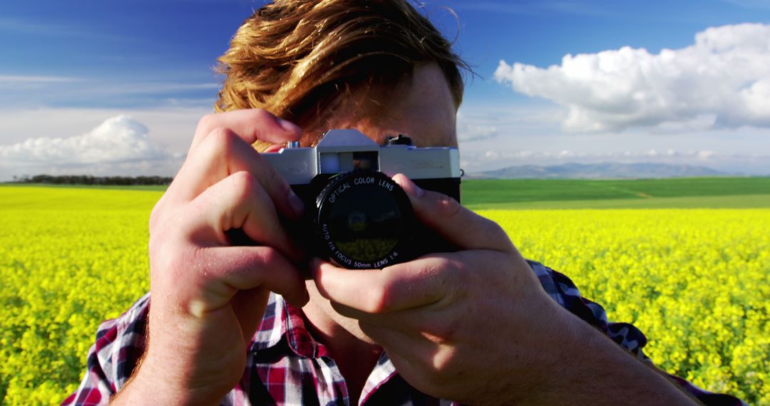 Young Photographer Capturing Yellow Field Under Blue Sky - Free Images, Stock Photos and Pictures on Pikwizard.com