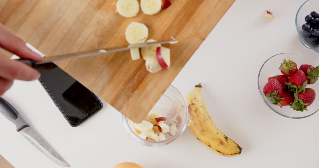 Hands Preparing Smoothie with Fresh Fruits in Modern Kitchen