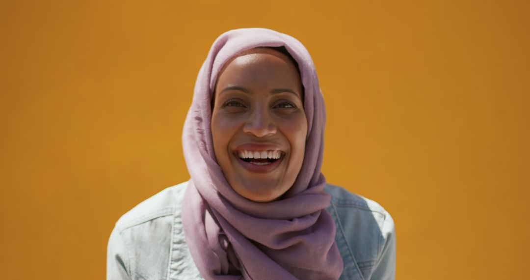 Cheerful Woman in Hijab Smiling Against Vibrant Yellow Background - Free Images, Stock Photos and Pictures on Pikwizard.com