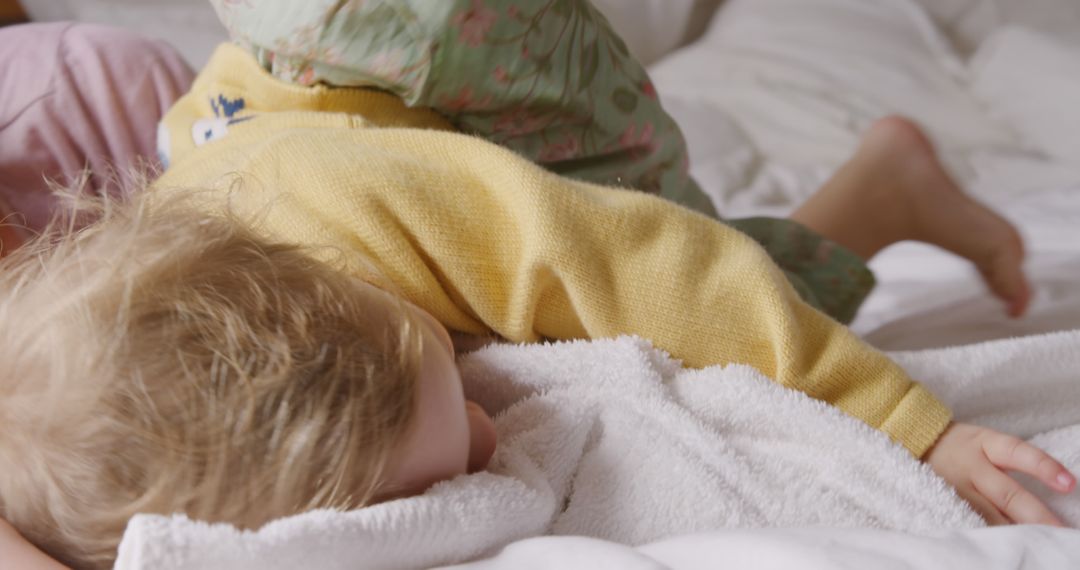 Young Child Sleeping in Cozy Bed with Yellow Sweater and Green Pants - Free Images, Stock Photos and Pictures on Pikwizard.com