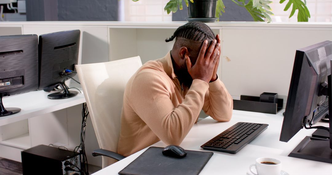 Stressed African American Man at Office Desk Facing Challenges