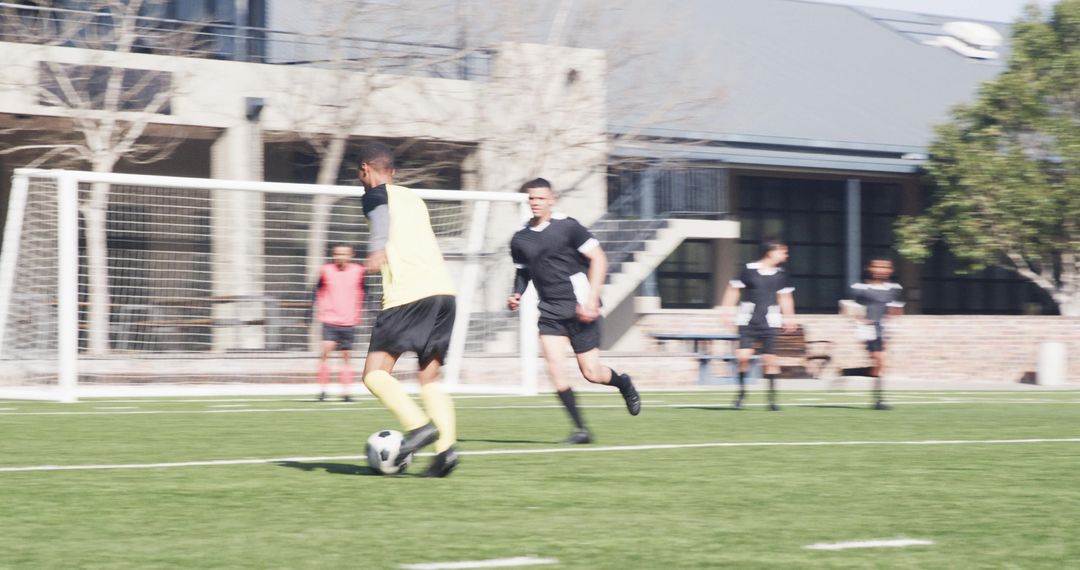 Soccer Players Competing Intently on Field with Goal Setup