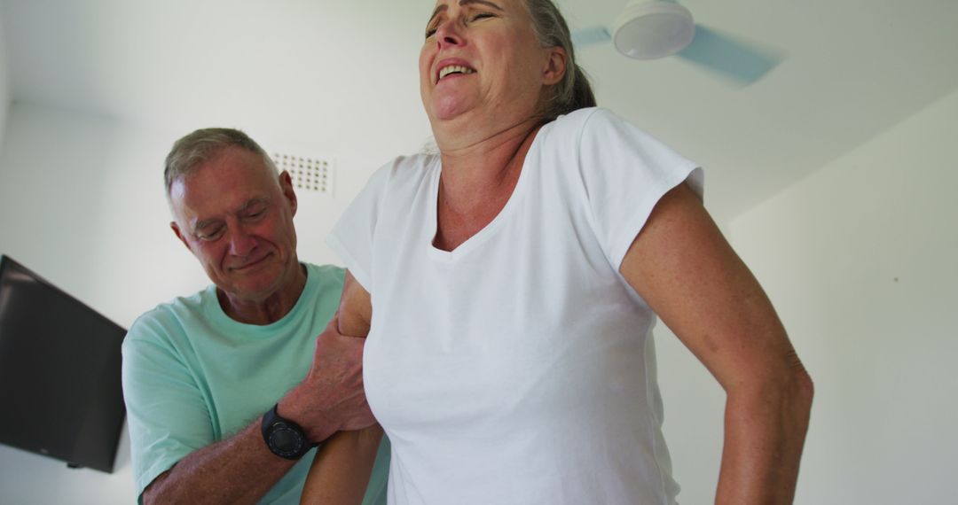 Senior Man Assists Wife with Walking Frame at Home