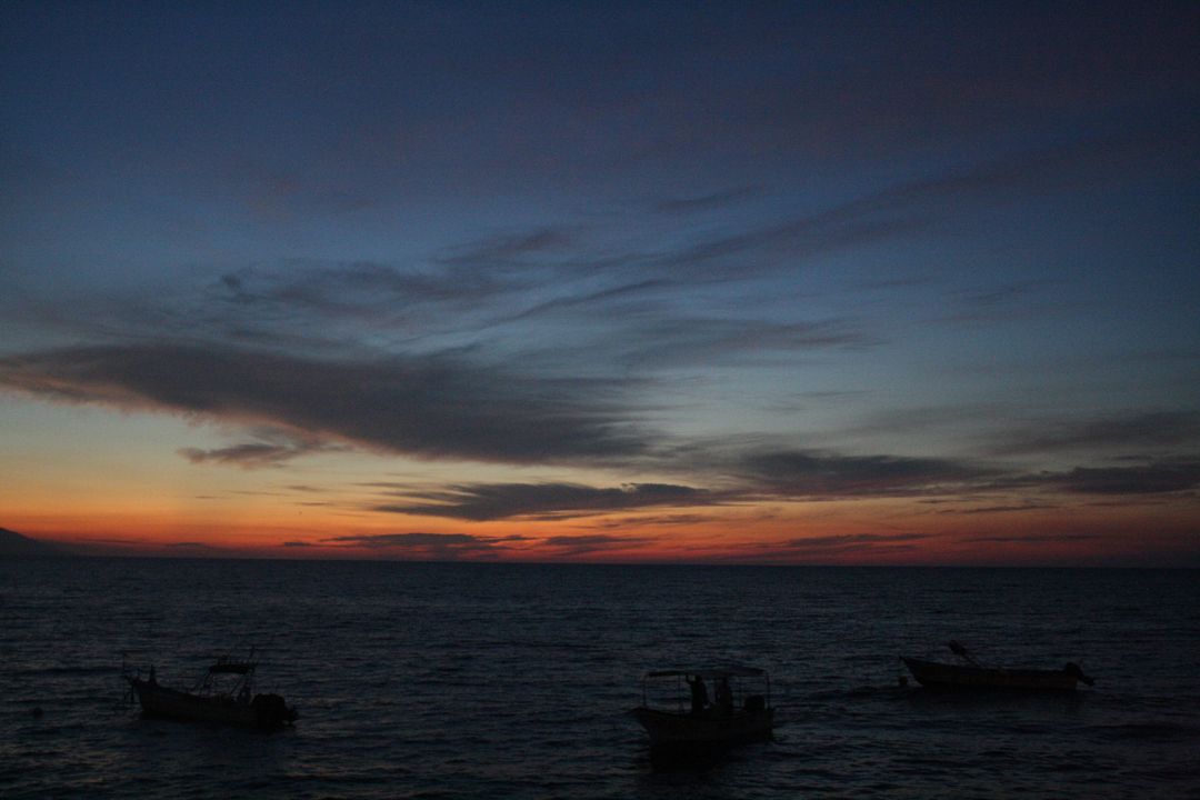Serene Coastal Sunset with Boats Silhouetted on Horizon - Free Images, Stock Photos and Pictures on Pikwizard.com