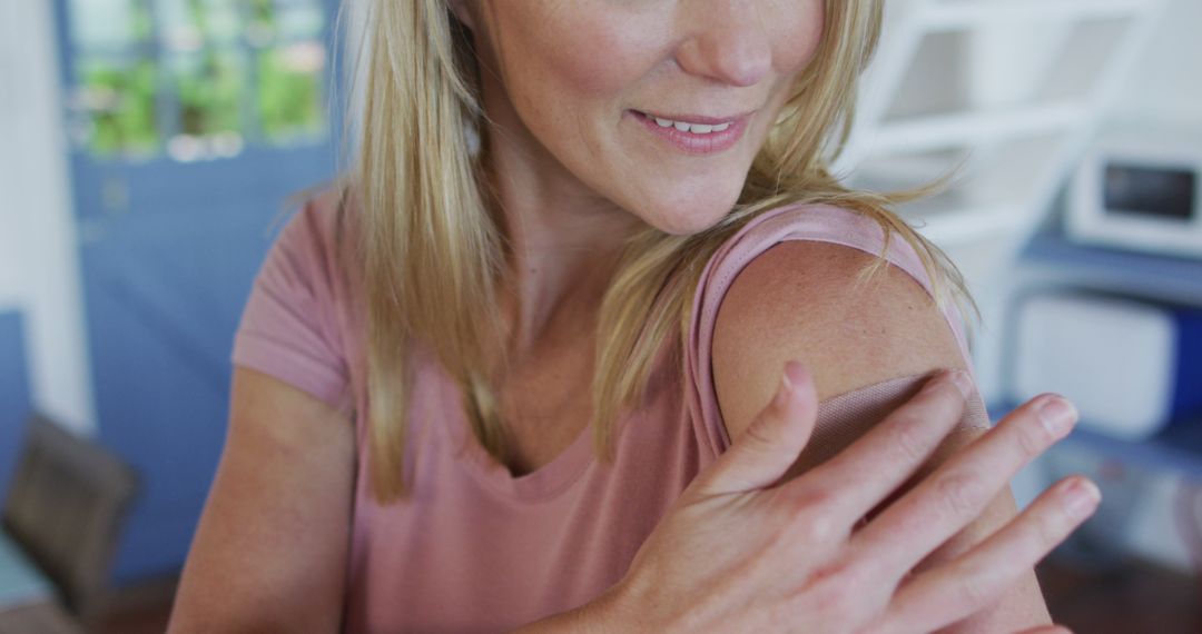 Smiling Woman Applying Sunscreen to Arm at Home - Free Images, Stock Photos and Pictures on Pikwizard.com