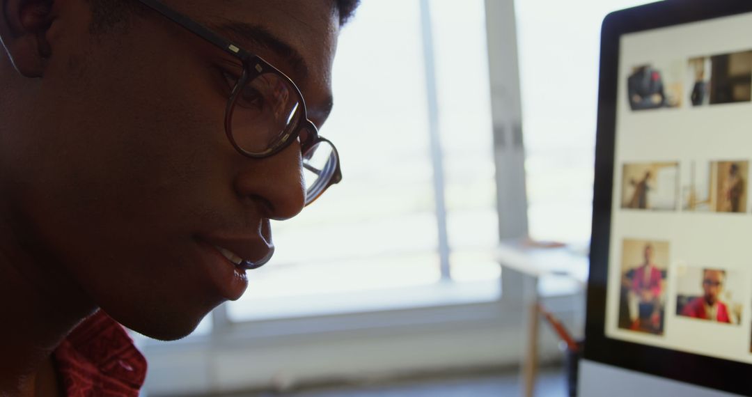 African American Designer Analyzing Photos on Desktop
