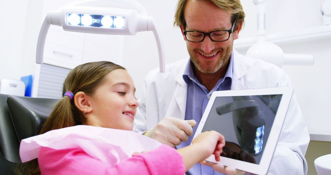 Pediatric Dentist and Young Girl Patient Using Digital Tablet in Dental Clinic - Free Images, Stock Photos and Pictures on Pikwizard.com