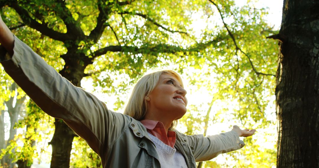 Joyful Woman Embracing Nature in Sunlit Park - Free Images, Stock Photos and Pictures on Pikwizard.com