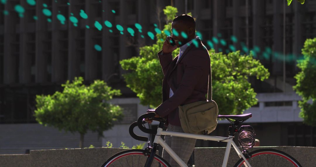 Urban commuter talking on phone while holding bicycle at city plaza in blazer