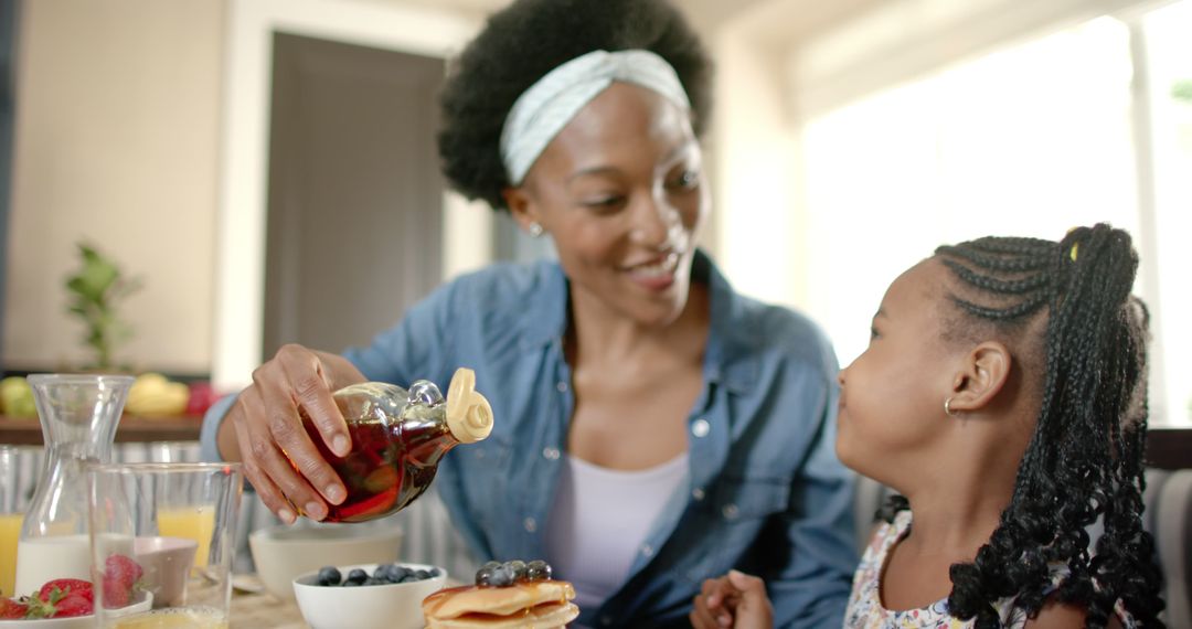 Loving Mother Pouring Syrup on Pancakes for Daughter During Breakfast - Free Images, Stock Photos and Pictures on Pikwizard.com