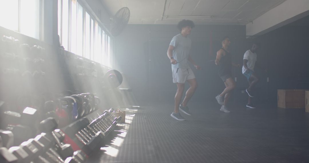 Men Jumping Rope Together in Gym with Weights Rack