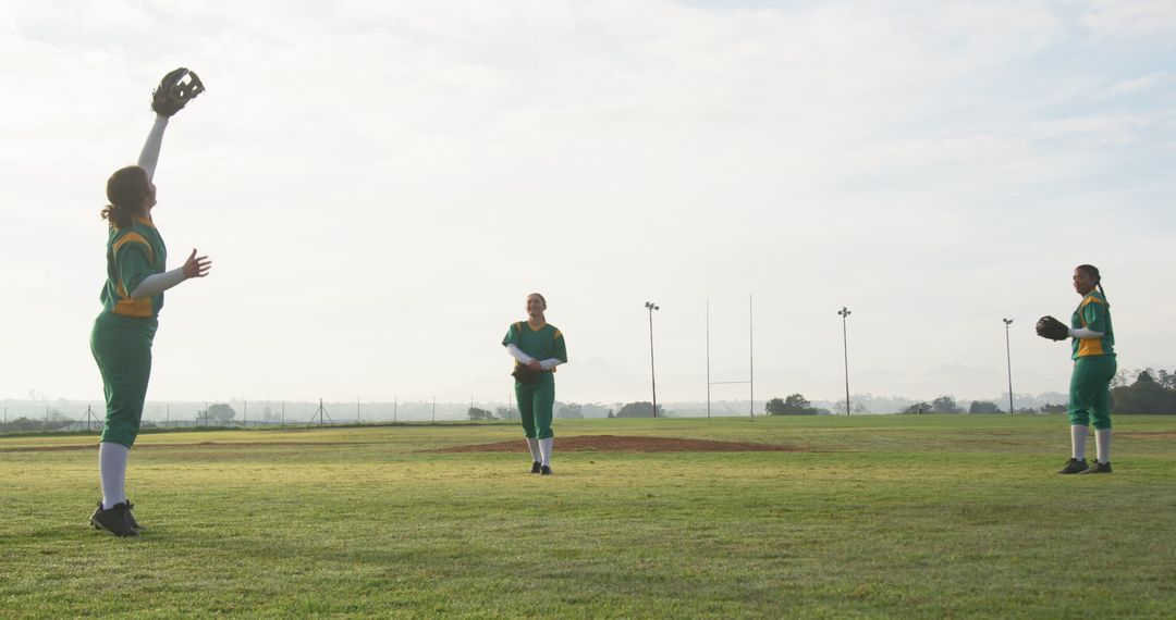 Diverse Female Softball Team Practicing on Green Field