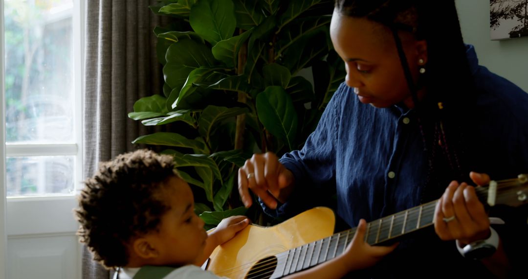 Parent Teaching Young Child to Play Guitar at Home - Free Images, Stock Photos and Pictures on Pikwizard.com