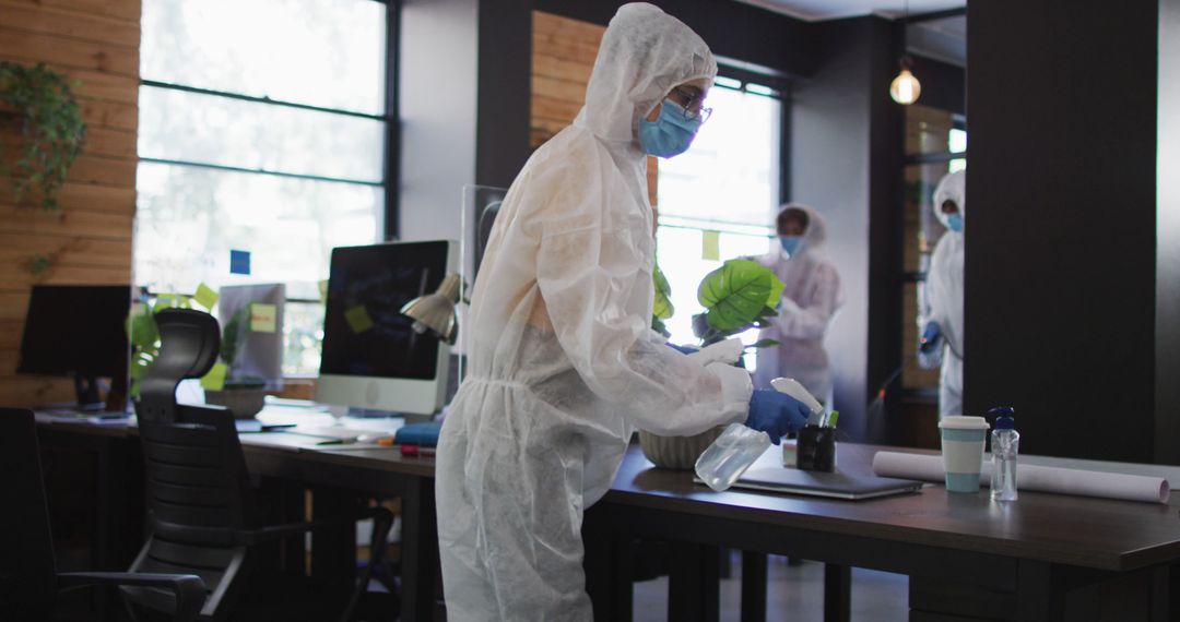 Cleaning staff in protective suits disinfecting office space - Free Images, Stock Photos and Pictures on Pikwizard.com