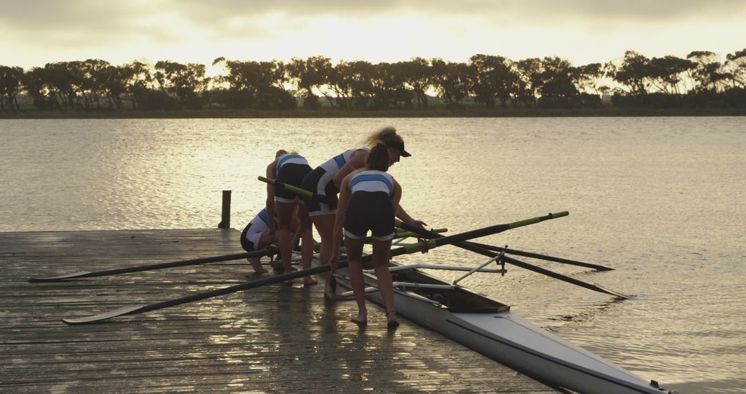 Rowing Team Preparing Boat at Lake Shore during Sunrise - Free Images, Stock Photos and Pictures on Pikwizard.com