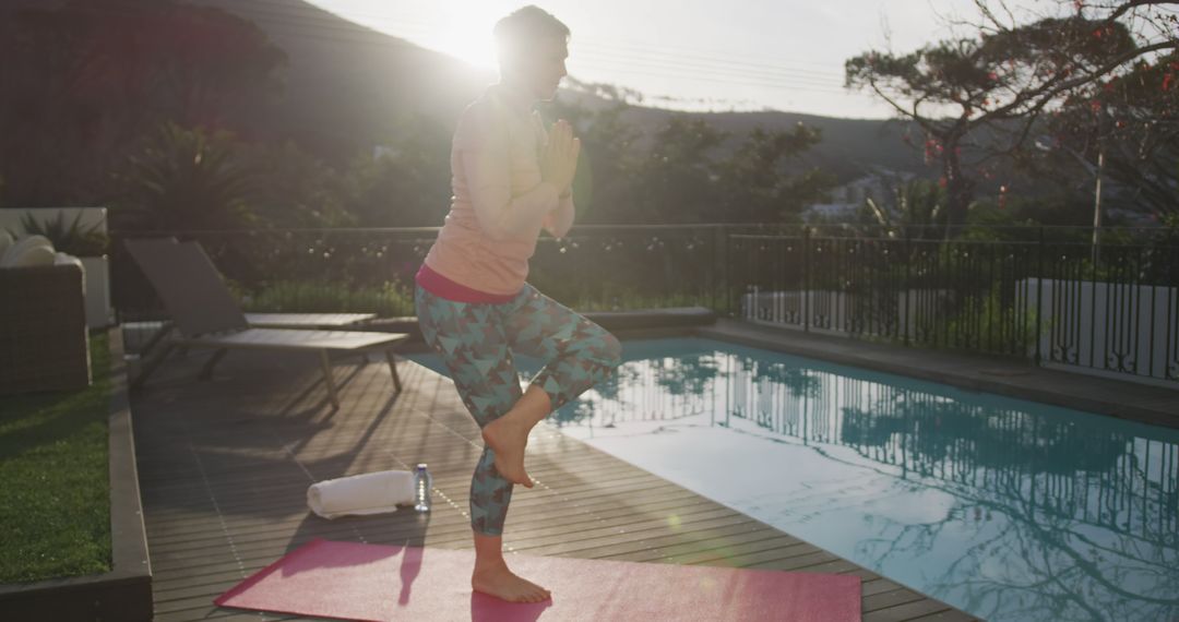 Woman practicing yoga at sunrise by swimming pool - Free Images, Stock Photos and Pictures on Pikwizard.com