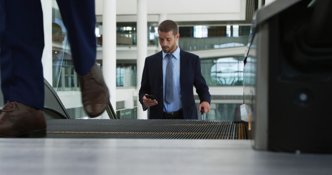 Businessman Checking Phone on Office Building Escalator