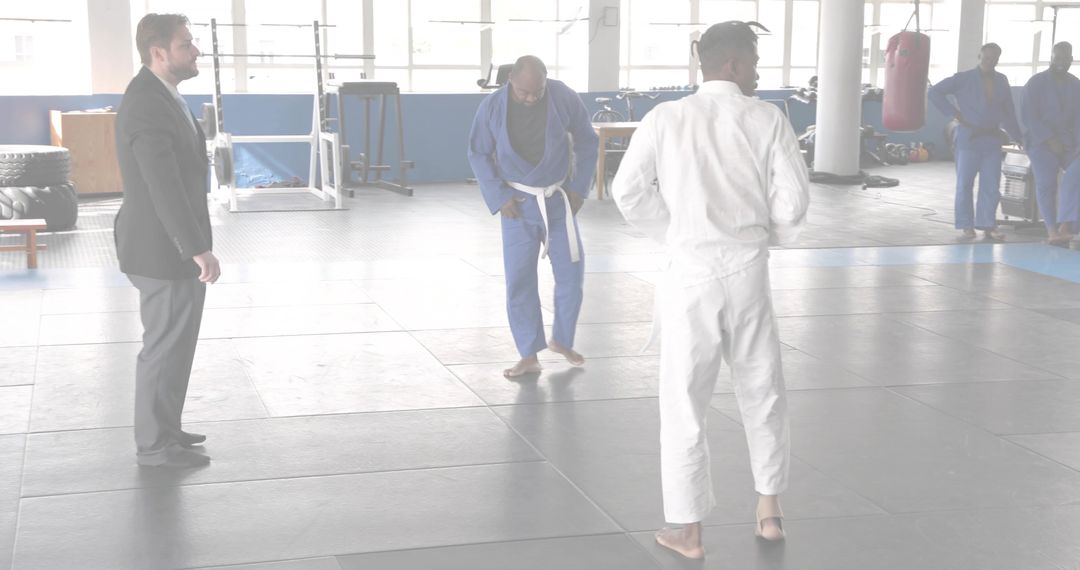 Martial arts instructor teaching Brazilian jiu-jitsu class on dojo mat with students training
