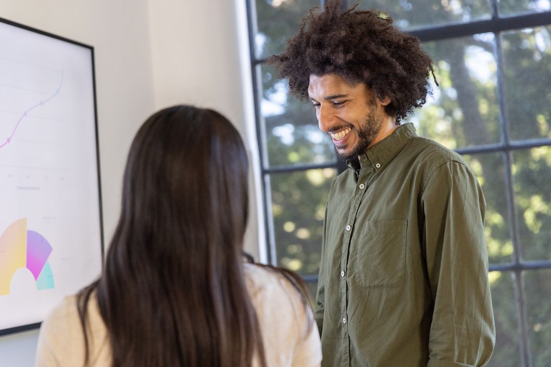 Coworkers Discussing Data in Office with Framed Chart Display
