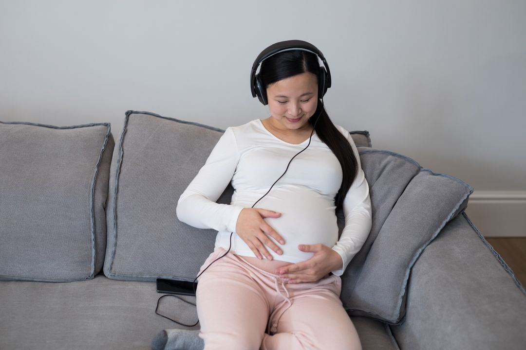 Pregnant woman listening music on headphones - Free Images, Stock Photos and Pictures on Pikwizard.com