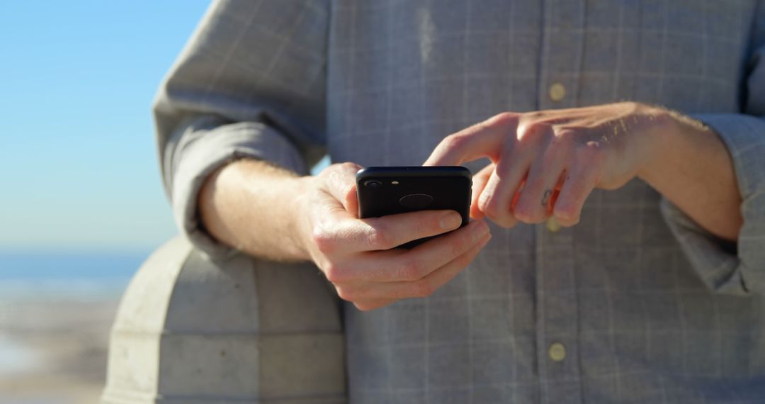 Person Typing on Smartphone Outdoors in Bright Sunlight - Free Images, Stock Photos and Pictures on Pikwizard.com