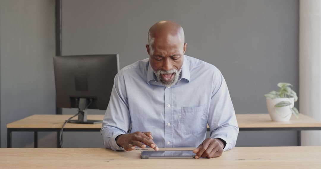 Mature Businessman Using Tablet in Modern Office