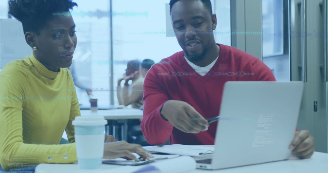Team Collaborating on Data Analysis Using Laptop in Office