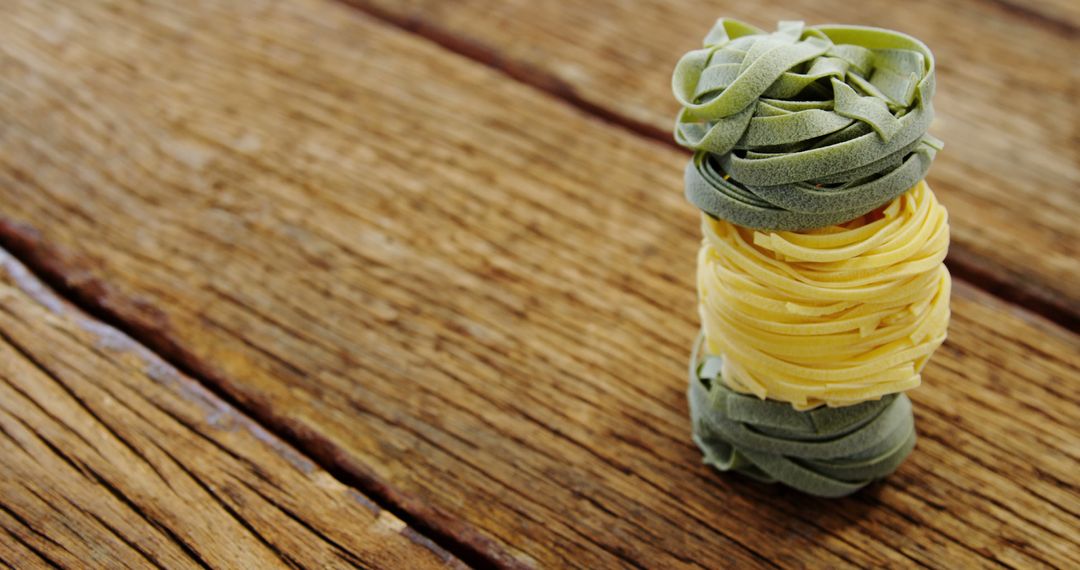 Stack of Colorful Pasta Nests on Wooden Table - Free Images, Stock Photos and Pictures on Pikwizard.com